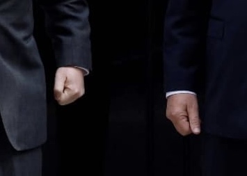 photo of two clenched fists that belong to (male) bureaucrats